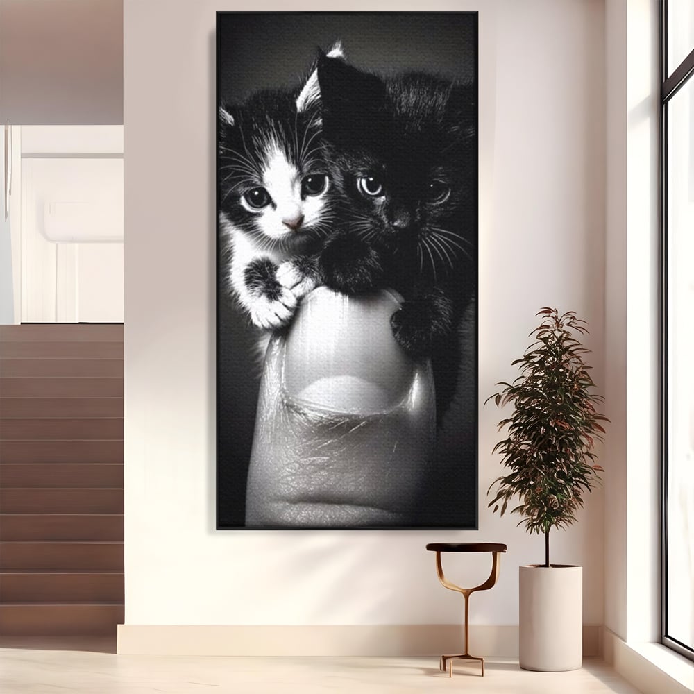 Tablou canvas cu tablou canvas cu doi pisoi mici agatati de un deget, in rama de aluminiu negru